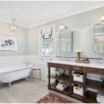 A bright bathroom with a tub and wood vanity