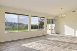 Empty living room with windows opening up to the backyard