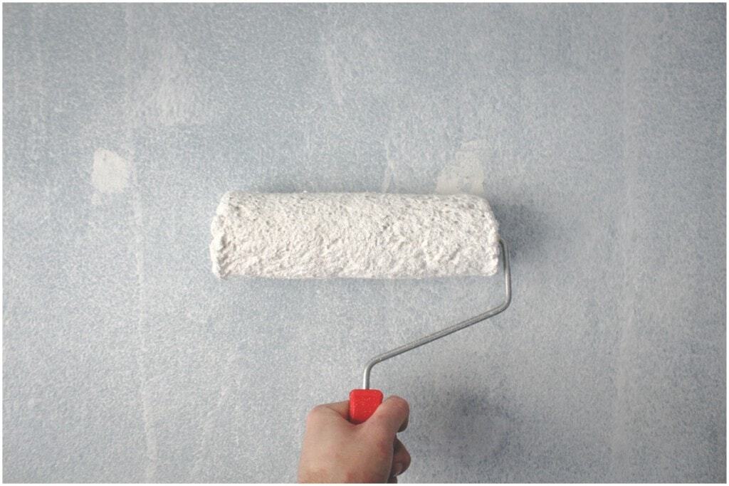 painting white paint on grey wall