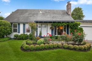 blue-house-front-porch-landscaped-yard