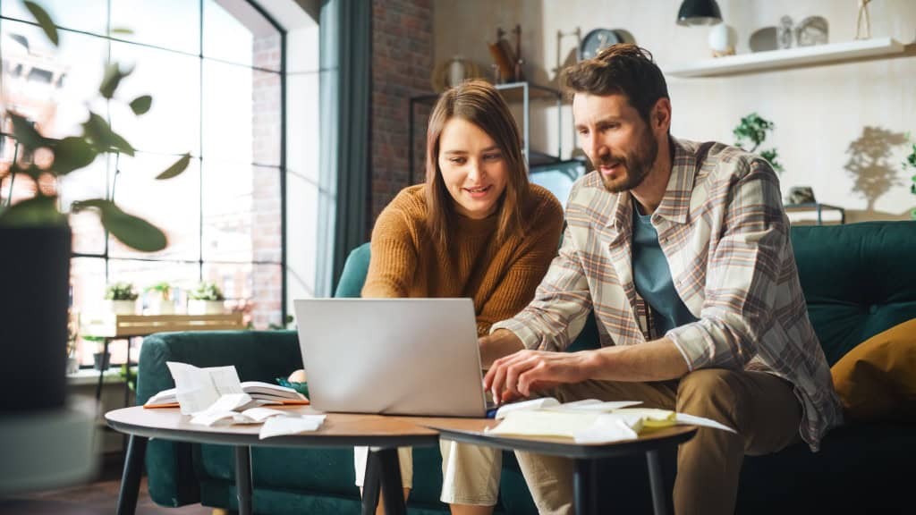 A young couple looks up how to buy a house without a realtor so they can buy their house on their own.