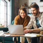 A young couple looks up how to buy a house without a realtor so they can buy their house on their own.