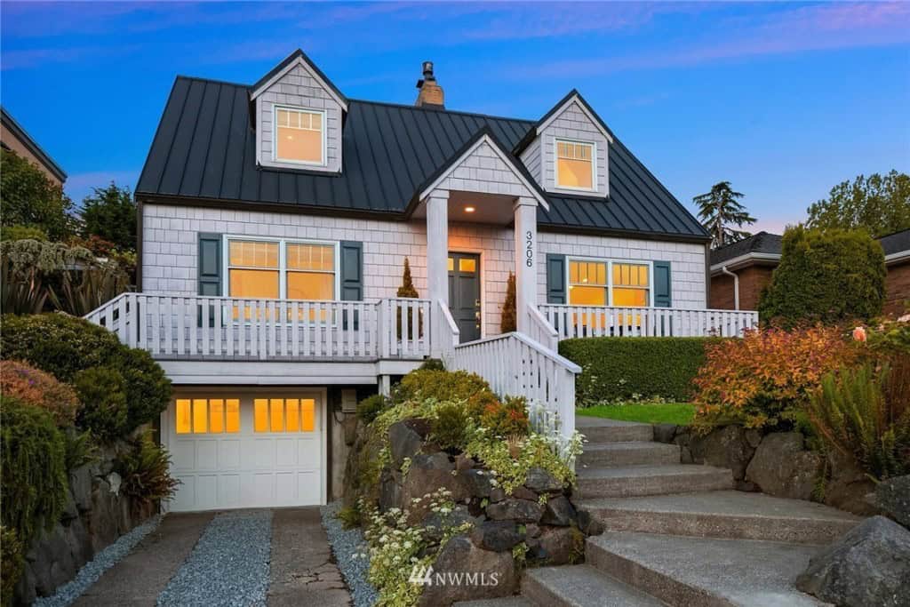 White Cape Cod House Style with blue shutters and a garage