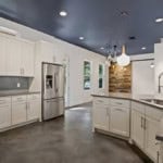 new kitchen with white cabinets and stone floors