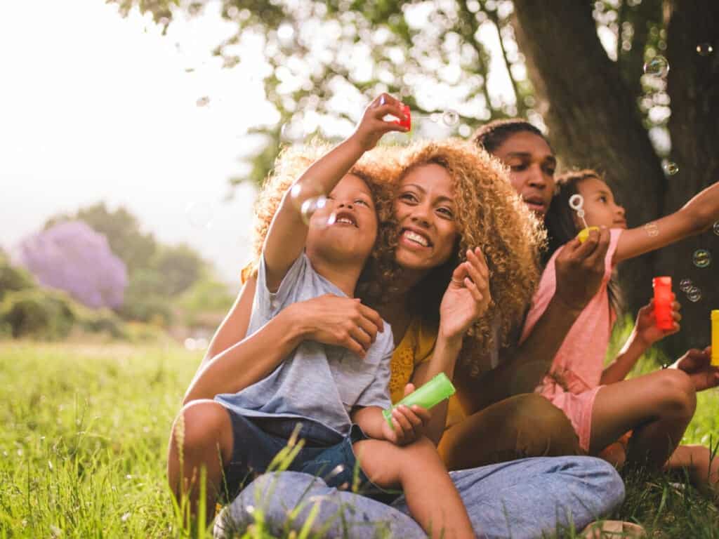 family blowing bubbles in a park