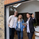Real estate agent showing a house for sale to a couple