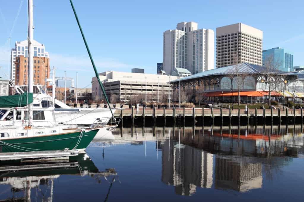 Norfolk Virginia waterfront on the banks of Chesapeake Bay. Norfolk is an independent city in the Commonwealth of Virginia in the United States. Norfolk is in the metro area called Hampton Roads. Norfolk is known for its coffee houses and breweries, world’s largest Naval base, museums, and beaches