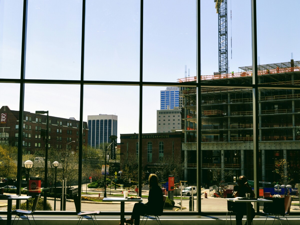 view from inside a building with large windows overlooking a street in arena district
