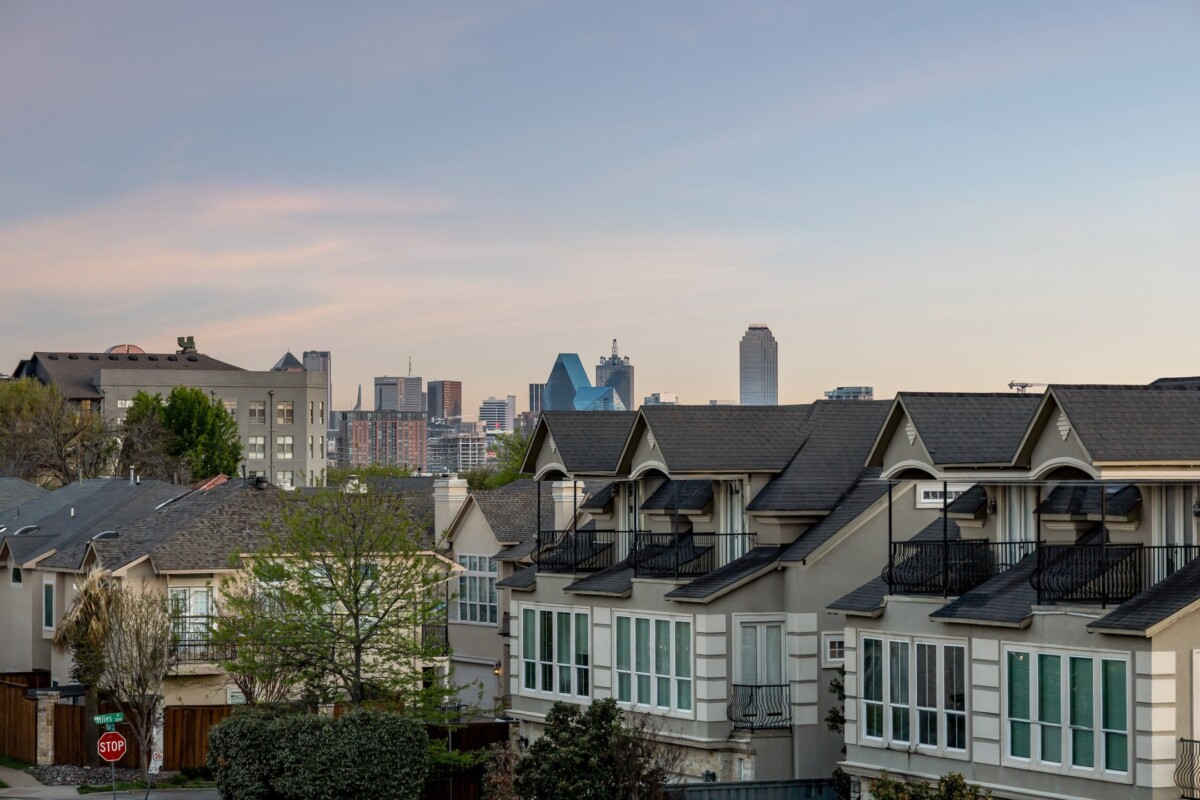 new condos in oak lawn dallas tx with view of city skyline in the distance at dusk