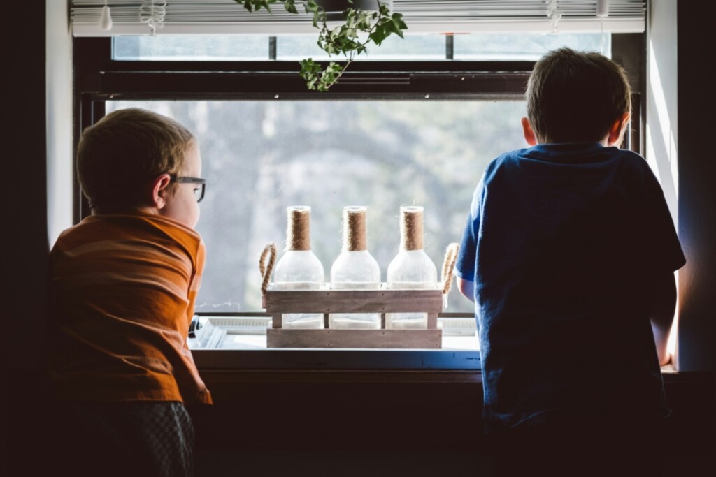 Two kids looking out the window