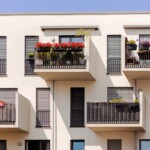 Balcony Facade of Modern Apartment Building. Garden Flowers on Balconies in Europe.