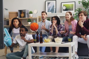 A group of people watching NBA Finals at home on a couch