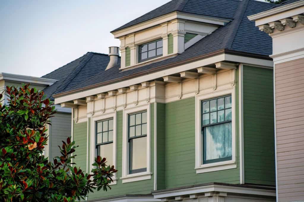 Hidden windows on the back of house or home in the suburban area of the downtown city in american suburb or urban area. In the neighborhood or with green and white exterior and windows.