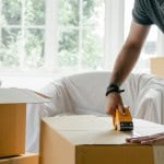 person taping a moving box