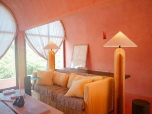 a pink color-washed room lit by two distinct, modern lamps