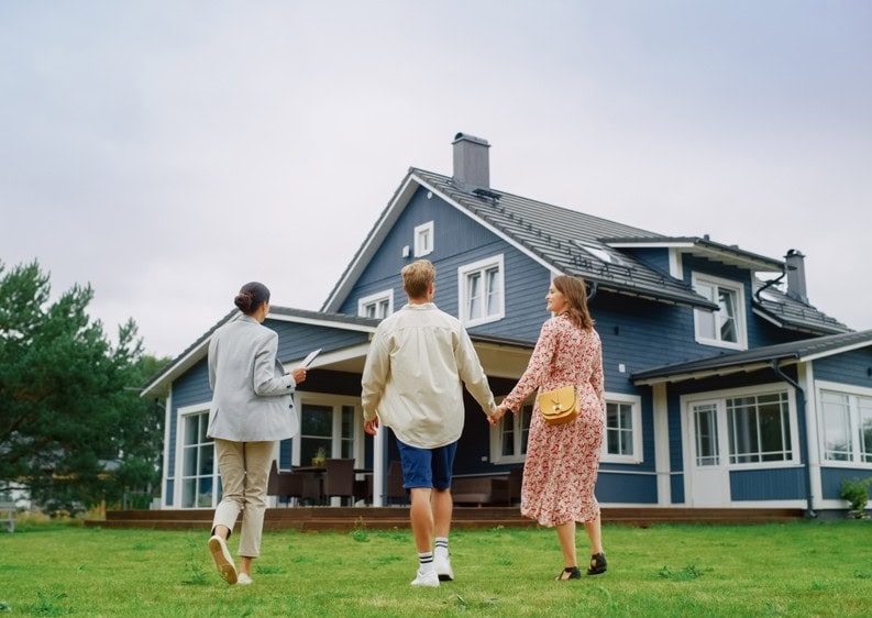 Homebuyers touring a property with their real estate agent, checking off items on their house hunting checklist