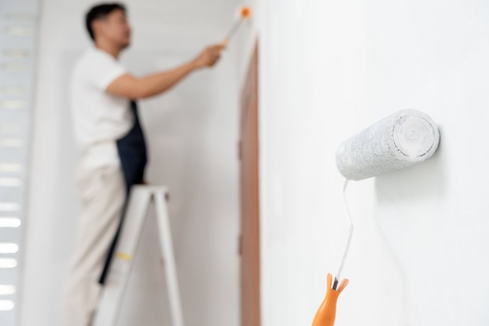 Man painting interior walls of a house