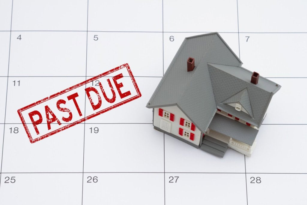 Mortgage payment due with house and red past due stamp on a calendar