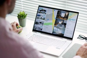 A person looking at an online home searching platform, shopping for homes on their computer