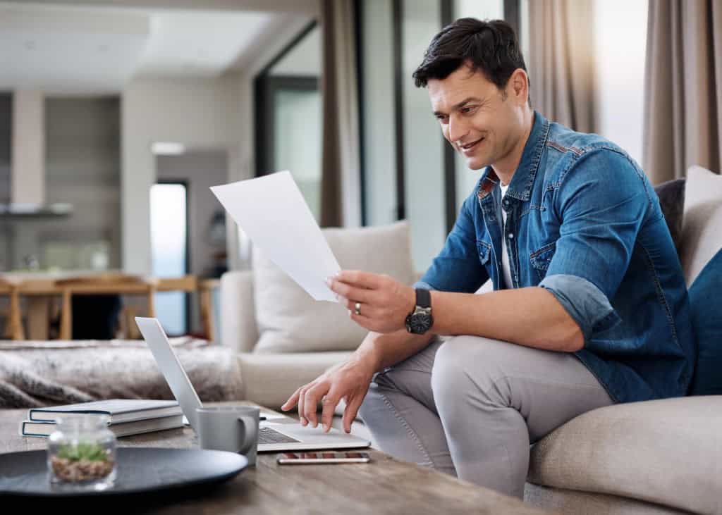 A photo of a man figuring out how much house he can afford with 80k salary.