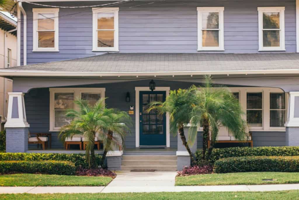 A blue house with palm trees infront
