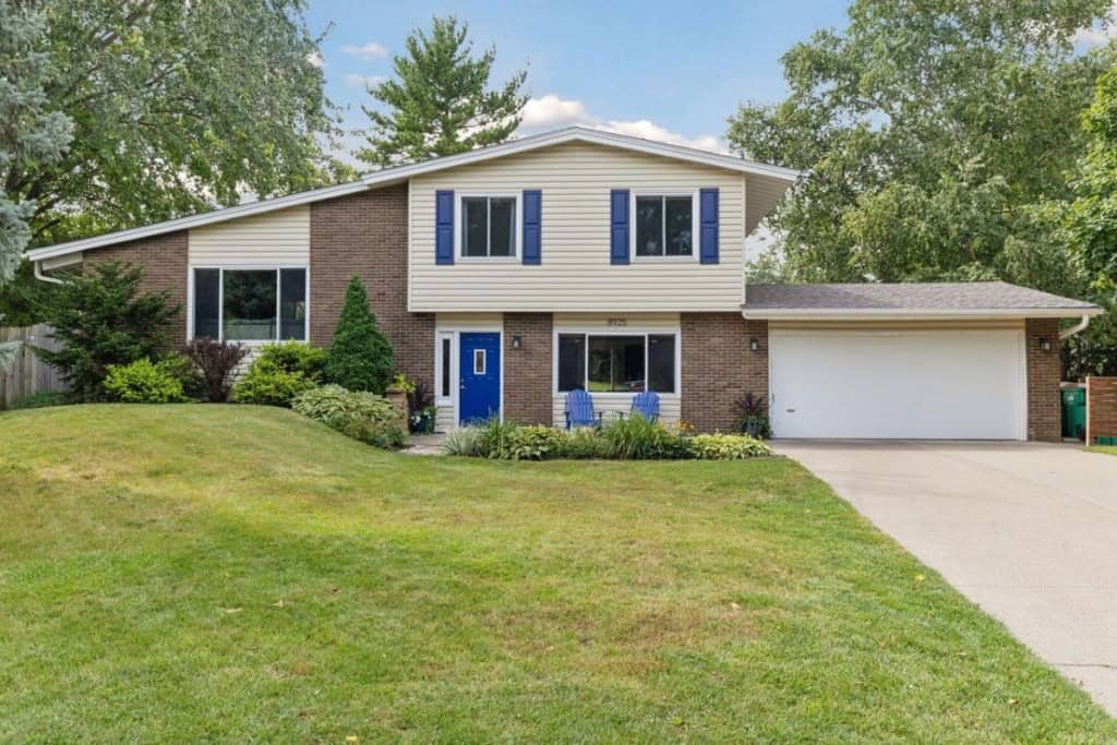 Home for sale in Minneapolis, MN with a large lawn and blue shutters.