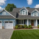 A new construction home sitting in a green suburban neighborhood.