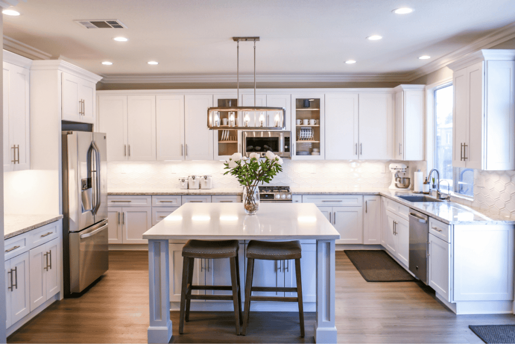 Modern kitchen with stainless steel appliances and white cabinetry, illustrating home fixtures that may be included or excluded in real estate sales, such as built-in appliances, lighting, and furniture