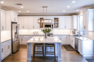 Modern kitchen with stainless steel appliances and white cabinetry, illustrating home fixtures that may be included or excluded in real estate sales, such as built-in appliances, lighting, and furniture