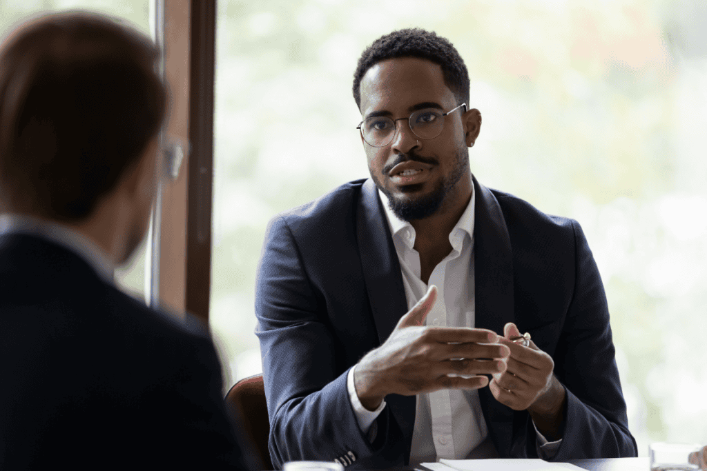 A professional man speaking during a business meeting, illustrating communication challenges common in non-disclosure states real estate transactions.