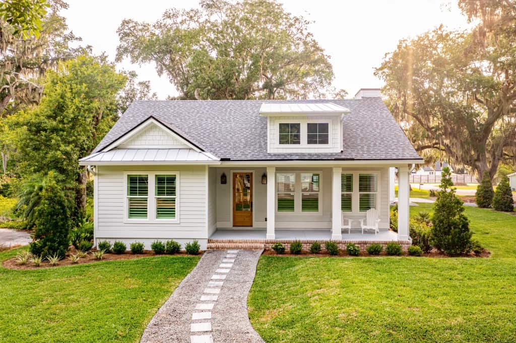 A white house with a pathway leading up to the front door. The owner might be wondering whether they should sell to an iBuyer.