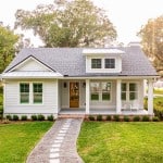 A white house with a pathway leading up to the front door. The owner might be wondering whether they should sell to an iBuyer.