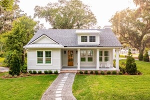 A white house with a pathway leading up to the front door. The owner might be wondering whether they should sell to an iBuyer.