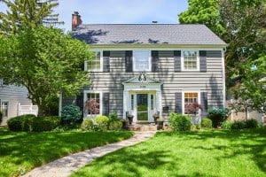 A two-story house with a pathway cutting through the grass leading up to the front door. A seller might want to know what it would be like selling this home to an iBuyer.