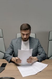 man reading paper siting at table