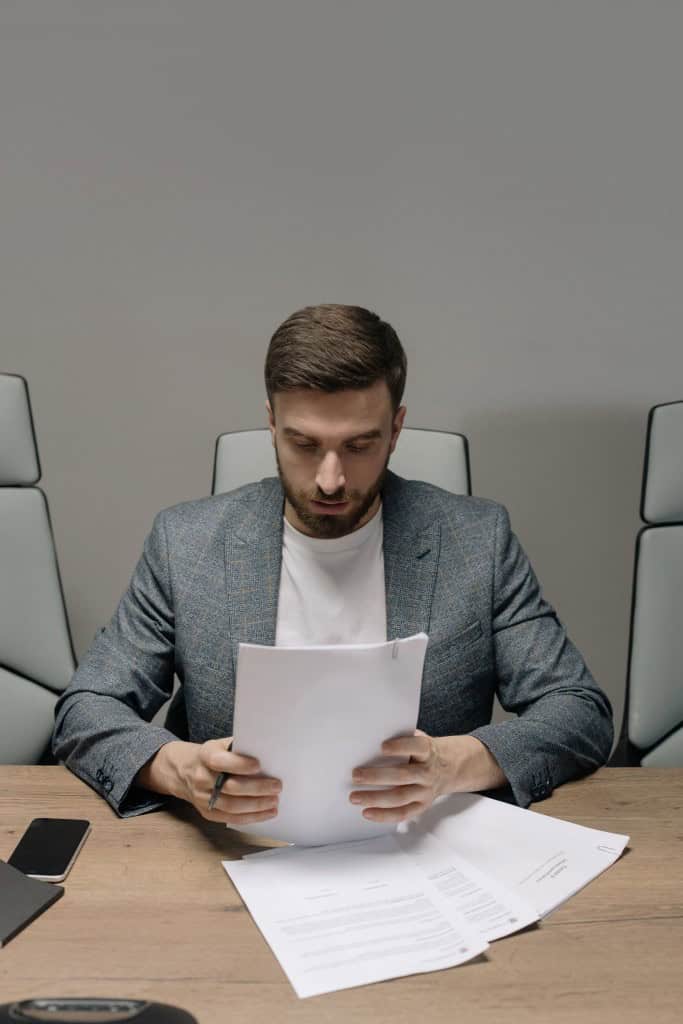 man reading paper siting at table