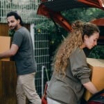 man and woman loading boxes into car